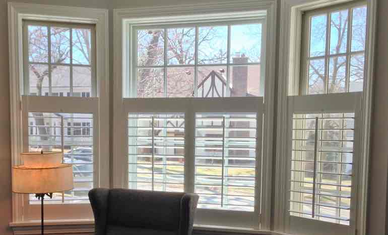 Half insulating shutters in living room bay window.